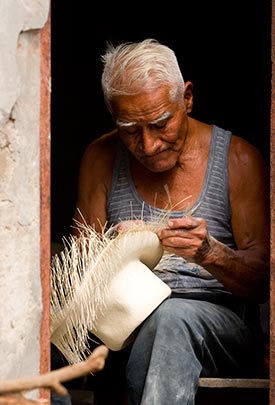 A Man works with a hat in a doorway