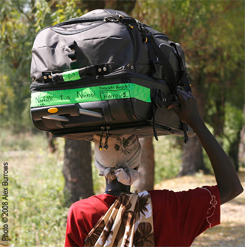 A porter carries a heavy bag on her head in Nairobi